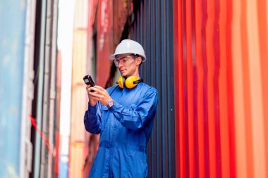 Mavi yakalı ve güvenlik üniformalı Kafkas kargo konteynırı. Ürünü kontrol etmek için barkod tarayıcısı kullanın ve iş yerindeki tankların arasında kalın..