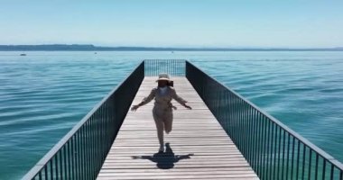 Aerial video of Carefree Woman Running on Pier