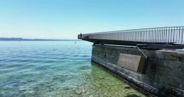 Aerial video of happy carefree woman standing on pier and looking at sea