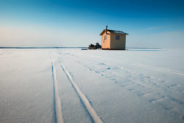 Buz kaplı bir göl üzerinde sarı-balık hut — Stok fotoğraf