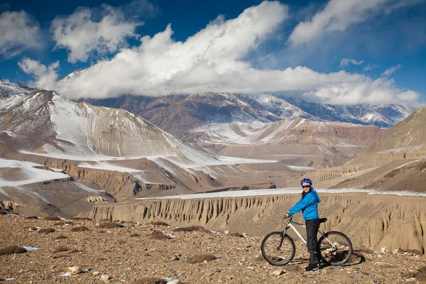 Kvinna cykling i hymalaya mounains under solig dag — Stockfoto