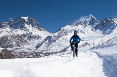 Himalayaların yüksek dağlarda kar kız bisiklet sürmek. Annapurna parça Himalayalar