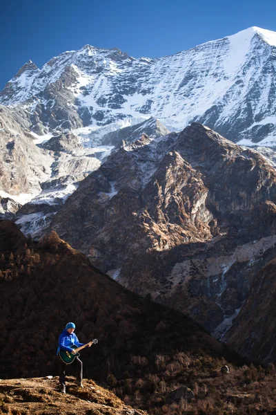 Mutlu kız Himalayaların yüksek dağlar arasında kar, gitar çalmak — Stok fotoğraf