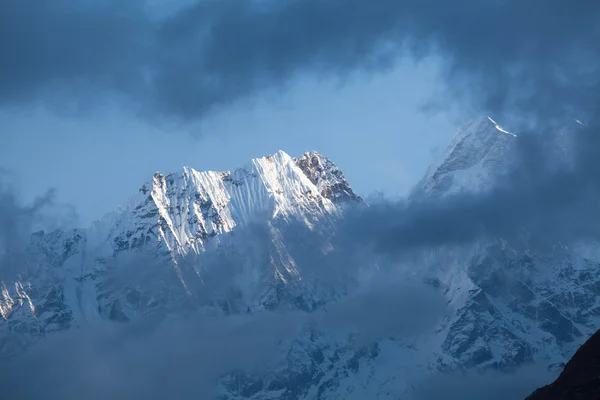 Besneeuwde toppen van de hoge bergen van de Himalaya in de wolken — Stockfoto