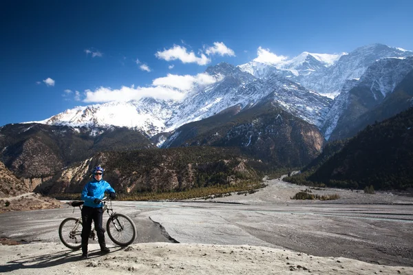 Chica con una bicicleta en las altas montañas del Himalaya. Annapurna pista —  Fotos de Stock