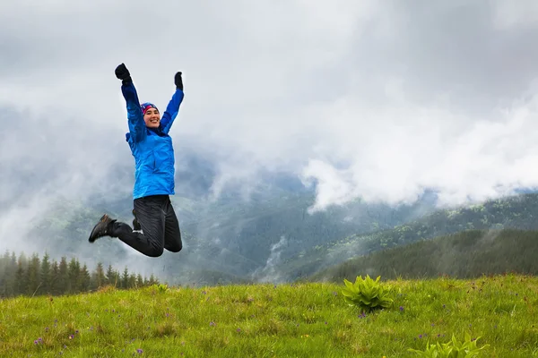 Glad tjej som hoppar i bergen — Stockfoto