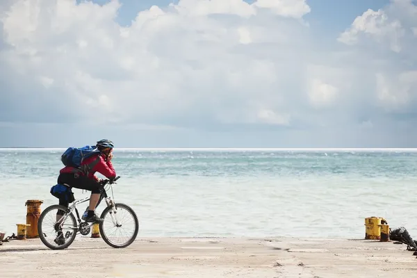 Man with a bicycle stands on the beach — Stock Photo, Image