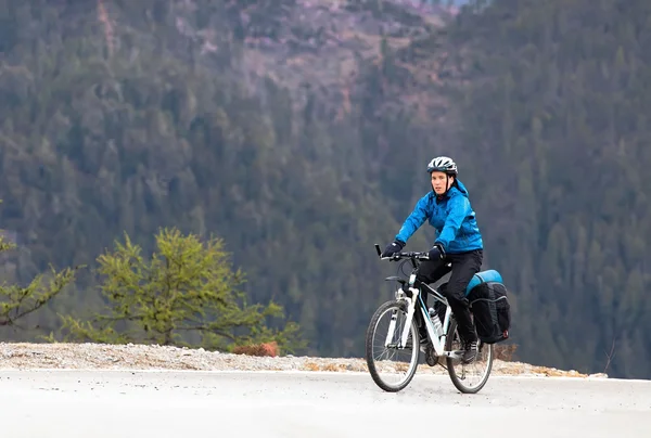 Dívka cyklista mezi vysokými horami — Stock fotografie