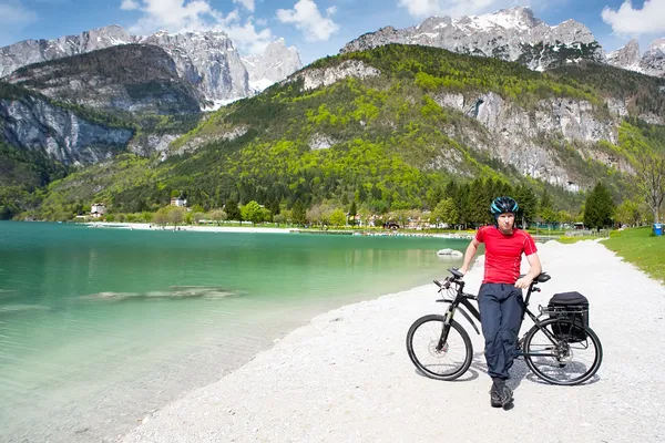Dağ gölünün kıyısında bir bisikletçi. — Stok fotoğraf