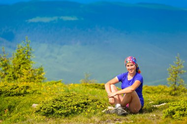 yeşil bir tepede bir tırmanıcı oturur