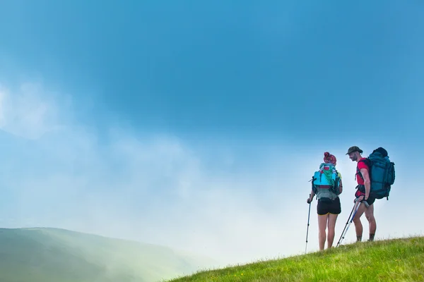 Woman and man standing on a green hill — Stock Photo, Image