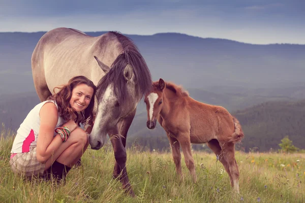 Meisje in de buurt van een wild paard — Stockfoto