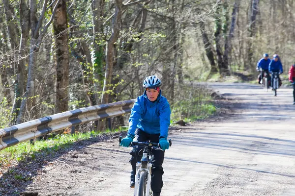 Amici in sella a bici su una strada forestale di montagna — Foto Stock