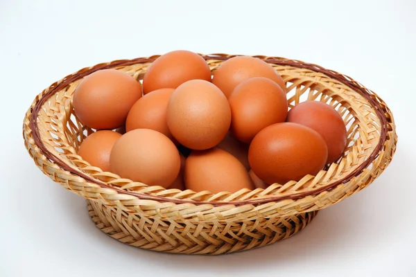 Huevos de colores en cesta de paja — Foto de Stock