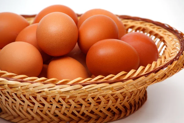 Colored eggs in straw basket — Stock Photo, Image