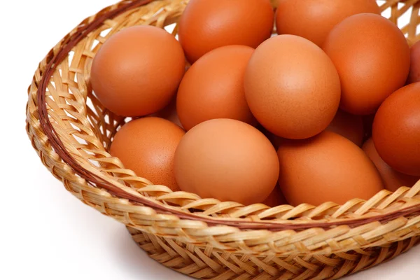 Colored eggs in straw basket — Stock Photo, Image