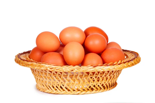 Colored eggs in straw basket — Stock Photo, Image