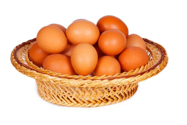 Colored eggs in straw basket — Stock Photo, Image