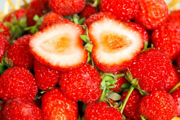 Many strawberries as a texture and sliced berry — Stock Photo, Image