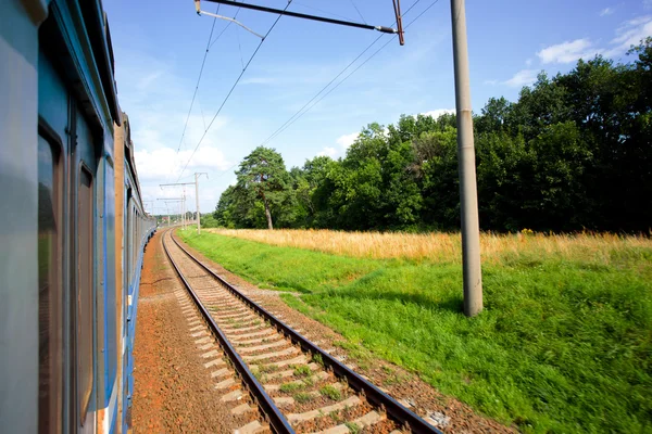 El tren acelera a lo largo de los rieles cerca del bosque — Foto de Stock