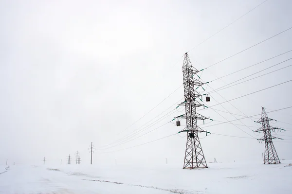 De lijn van de macht in de buurt van de weg in de winter — Stockfoto