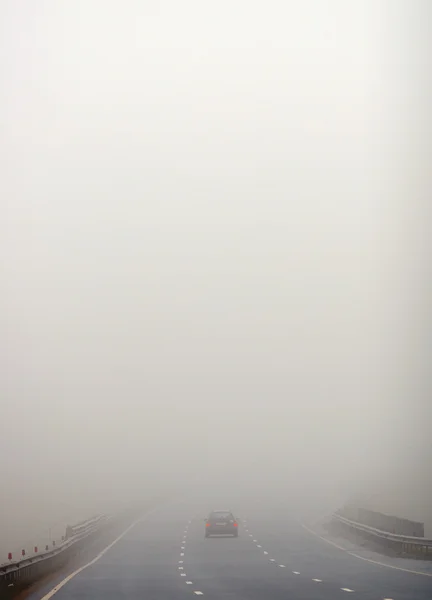 Carretera y un coche en niebla — Foto de Stock