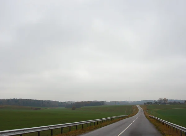 Vägen under en molnig himmel i höst — Stockfoto