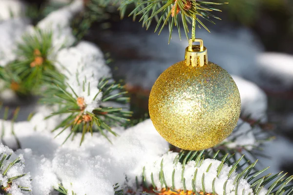 Gelbe Kugel auf dem Weihnachtsbaum mit Schnee — Stockfoto