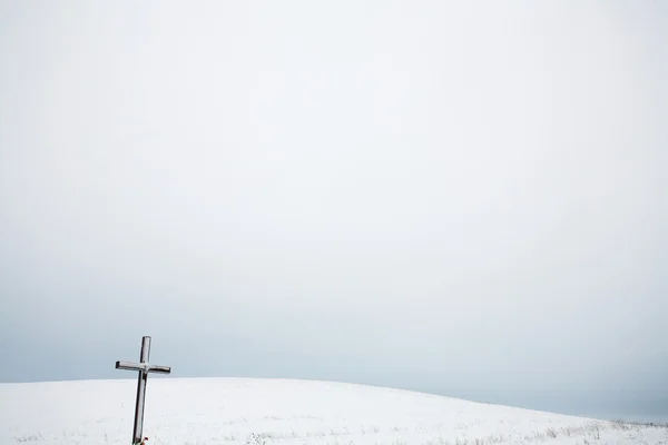 Paysage hivernal avec colline de neige et croix — Photo