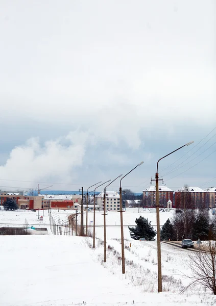 Stad winterlandschap met lijn van de macht, huizen en weg — Stockfoto