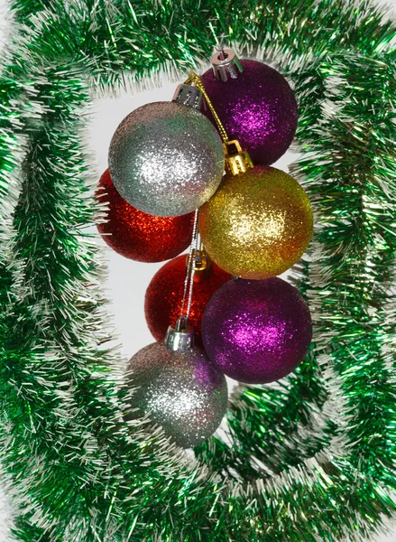 Colored Christmas balls on a green tinsel as a symbol of the New year — Stock Photo, Image