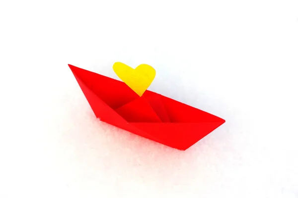 Red paper boat with a heart in the snow — Stock Photo, Image