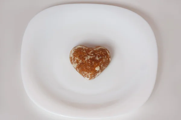 Tatlım bir plaka üzerinde kalp şeklinde pasta