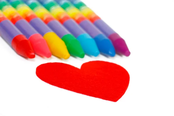 Red heart shape and colored chalks, crayons — Stock Photo, Image