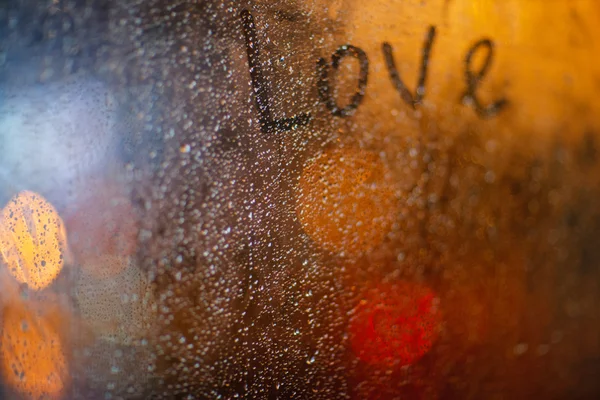 在雨中在窗户上"爱"这个词 — 图库照片