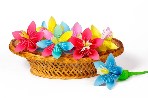 Many colored paper flowers in the basket and one flower near the basket — Stock Photo, Image