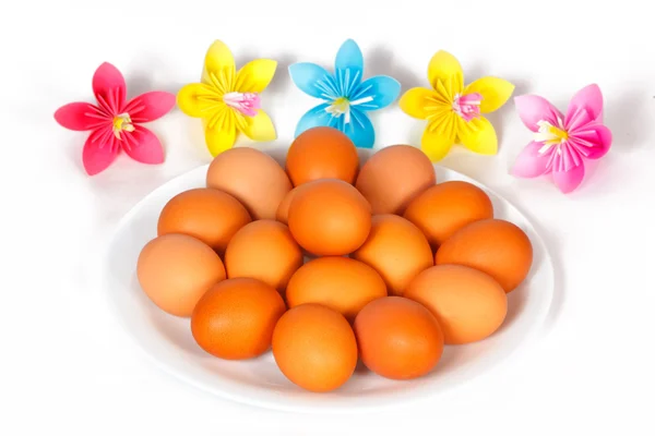 Huevos de Pascua en el plato con flores de papel — Foto de Stock