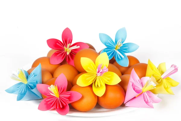 Easter eggs on the plate with a paper flowers — Stock Photo, Image