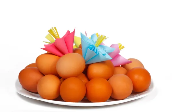 Easter eggs on the plate with a paper flowers — Stock Photo, Image