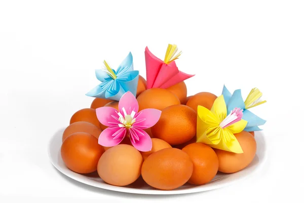 Easter eggs on the plate with a paper flowers — Stock Photo, Image