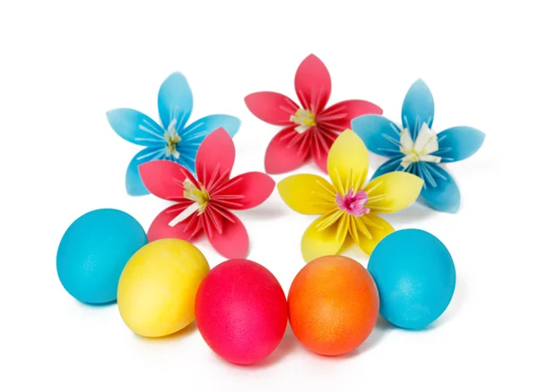 Many Easter eggs and colored paper flowers — Stock Photo, Image