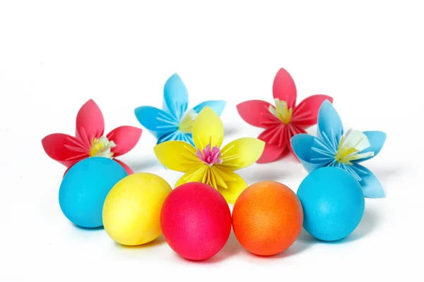 Muchos huevos de Pascua y flores de papel de colores — Foto de Stock