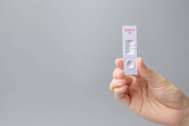 Rapid Antijen Test kiti tutan adam COVID-19 testi sırasında negatif sonuç verdi. Coronavirus Öz-Burun ya da Ev Testi, Kilitleme ve İzolasyon Konsepti