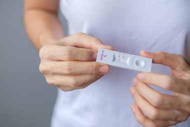 Rapid Antijen Test kiti tutan adam COVID-19 testi sırasında negatif sonuç verdi. Coronavirus Öz-Burun ya da Ev Testi, Kilitleme ve İzolasyon Konsepti