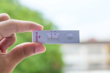 Rapid Antijen Test kiti tutan adam COVID-19 testi sırasında negatif sonuç verdi. Coronavirus Öz-Burun ya da Ev Testi, Kilitleme ve İzolasyon Konsepti