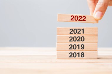 2022 bloğu 2021, 2020 ve 2019 numaralı ahşap bina üzerinde çekiliyor. İş planlaması, Risk Yönetimi, Çözüm, strateji, çözüm, hedef, Yeni Yıl ve mutlu tatil kavramları