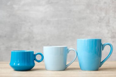 Sabahları mavi kahve fincanı ve ahşap masa arkasında çay fincanı, mesaj için boş fotokopi alanı. Uluslararası kahve günü ve günlük rutin konsept