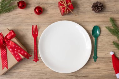 Tabak, çatal ve kaşıkla tahta masa arkaplanlı mutlu Noeller. Xmas, parti ve mutlu yıllar konsepti.