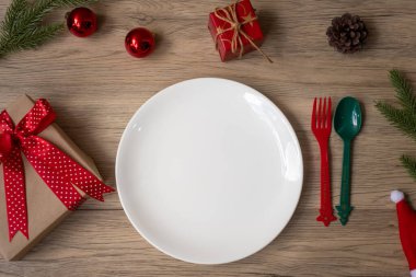 Tabak, çatal ve kaşıkla tahta masa arkaplanlı mutlu Noeller. Xmas, parti ve mutlu yıllar konsepti.