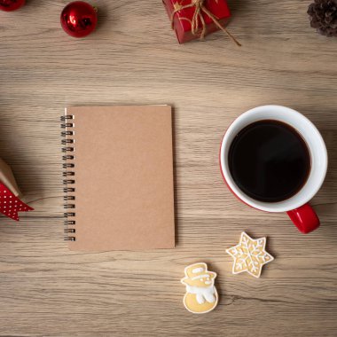 Boş defter, sade kahve fincanı, Noel kurabiyeleri ve tahta masa üzerindeki kalem, üst manzara ve fotokopi alanı. Xmas, Mutlu Yıllar, Hedefler, Kararlılık, Yapılacaklar listesi, Strateji ve Planlama konsepti